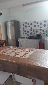 eine Küche mit einem Tisch und einem Kühlschrank in der Unterkunft Karibu in Rivière du Rempart