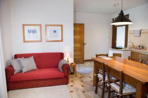 a living room with a red couch and a table at Appartamento al Birrificio in Valeggio sul Mincio