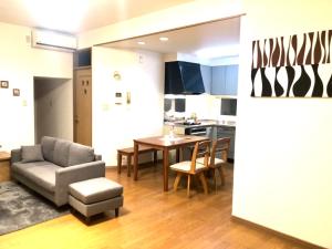 a living room with a couch and a table at Aioi Lodge in Otaru