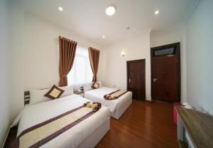 a hotel room with two beds and a television at Tommy hotel khe sanh dalat in Da Lat