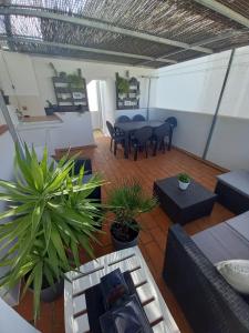 een kamer met een tafel, stoelen en planten bij Casa El Molino in Conil de la Frontera