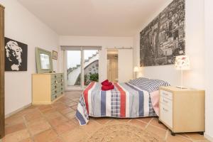 a bedroom with a bed and a dresser and a window at Flamenco Soul in Chiclana de la Frontera