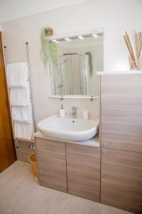 un baño con lavabo y espejo en Appartamento al Birrificio, en Valeggio sul Mincio 37 fotos más