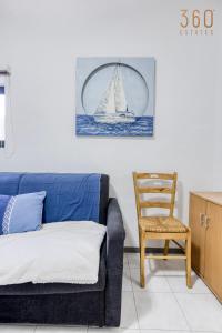 a living room with a couch and a sailboat on the wall at Peaceful 1BR maisonette with Sofa Bed with WIFI by 360 Estates in St. Paul's Bay