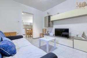 een woonkamer met een bank en een tafel bij Peaceful 1BR maisonette with Sofa Bed with WIFI by 360 Estates in St Paul's Bay