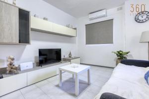 Peaceful 1BR maisonette with Sofa Bed with WIFI by 360 Estates في خليج سانت بول: غرفة معيشة بيضاء مع تلفزيون وطاولة