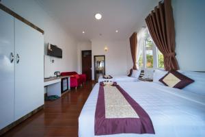 a hotel room with two beds and a kitchen at Tommy hotel khe sanh dalat in Da Lat
