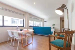 a living room with a table and chairs and a blue couch at Picaria - Orange in Porto
