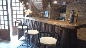 a bar with three stools at a counter in a room at The Tavern in Castelnau-Pégayrols