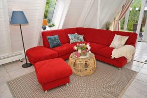丹普的住宿－_ viel Platz fuer Ihren Urlaub，客厅里设有一张红色的沙发和一把椅子