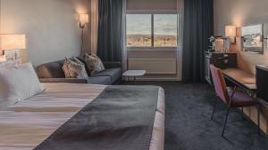 ヨーテボリにあるQuality Hotel Waterfrontのベッドとソファ付きのホテルルーム