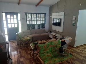 a living room with a couch and a tv at Chácara Rancho da Felicidade in Mogi das Cruzes