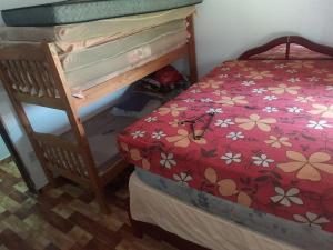 a bedroom with a bunk bed with a red bedspread with flowers at Chácara Rancho da Felicidade in Mogi das Cruzes