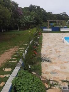 a garden with plants next to a swimming pool at Chácara Rancho da Felicidade in Mogi das Cruzes
