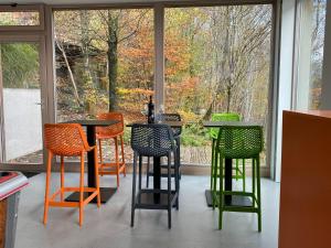 eine Gruppe von Stühlen und Tischen vor einem Fenster in der Unterkunft CHAMBRES PERCHEES in Weismes