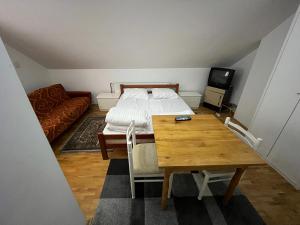 a bedroom with a bed and a table and a couch at Apartments and Rooms Vicko in Brzeće