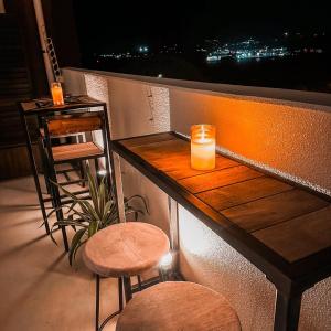 Un balcón con un bar con una vela y un taburete en オーシャンテラス瀬底 Room403, en Motobu