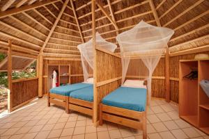 a room with two bunk beds in a bamboo house at Pine Beach Bungalows all inclusive in Pakoštane