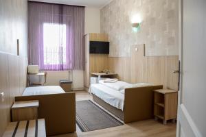 a small bedroom with two beds and a window at Korona Vendégház in Mátészalka
