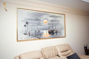 a painting hanging on a wall with a couch at Beach bliss 3BR apartment Corniche in Abu Dhabi