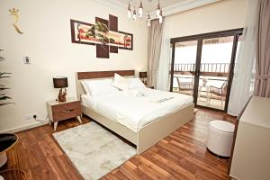 a white bedroom with a bed and a window at Beach bliss 3BR apartment Corniche in Abu Dhabi