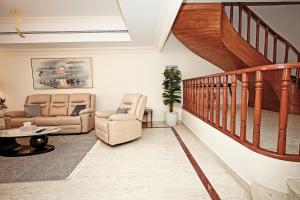 sala de estar con 2 sillas y escalera en Beach bliss 3BR apartment Corniche, en Abu Dabi