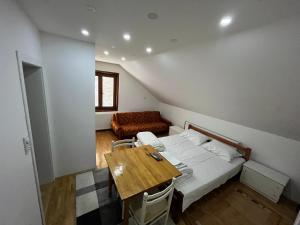 a bedroom with a bed and a table and a couch at Apartments and Rooms Vicko in Brzeće