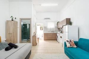 a living room with a blue couch and a kitchen at Cozy and Traditional - EC Studios in Larnaka