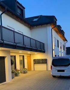 une voiture blanche garée devant une maison dans l'établissement Wohnen auf Zeit - Dachgeschosswohnung mit Bergblick, à Bruckmühl