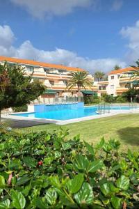 un resort con piscina di fronte a un edificio di Los Cancajos Apartamento Acijoa a Los Cancajos