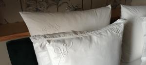 two white pillows sitting on a bed next to each other at Maison 1949 in Saint-Sauveur-le-Vicomte
