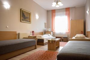 ein Hotelzimmer mit 2 Betten und einem Fenster in der Unterkunft Korona Panzió in Mátészalka