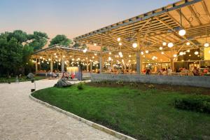 a pavilion with people sitting at tables in a park at Pine Beach Bungalows all inclusive in Pakoštane +61 photos