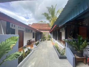 a walkway between two buildings with trees and plants at Krui Saejadi Surf and Stay in Krui