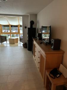 a room with a counter with a television and a mirror at Ferienhaus Fichte in Todtmoos