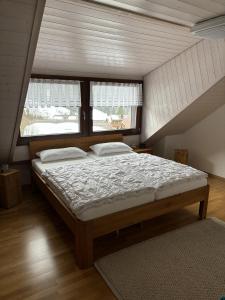 a large bed in a room with two windows at Ferienhaus Fichte in Todtmoos
