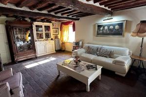 ein Wohnzimmer mit einem Sofa und einem Couchtisch in der Unterkunft Borgo Bucatra Proprietà in Lucca
