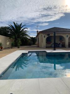 a swimming pool in front of a house at Traumhaus für 6 Personen mit spektakulärem privaten Pool und schönem Ausblick in die Natur in Hozanejos