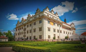 um grande edifício branco com um jardim em frente em Prázdninové ubytování - celý byt jen Váš em Litomysl