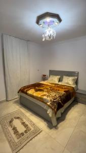 1 dormitorio con 1 cama con lámpara de araña en el techo en شقة فندقية قريبه من مطار القاهره الدولي, en El Cairo