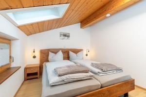 two beds in a bedroom with a skylight at Ferienwohnungen Marietta in Reit im Winkl