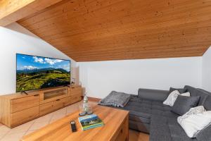 a living room with a couch and a flat screen tv at Ferienwohnungen Marietta in Reit im Winkl