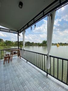 a balcony with a view of the water at Eden House Resort in Nakhon Nayok