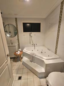 a white bathroom with a tub and a toilet at Book this Cozy Haven Room for your next stay Shared Facilities in Guildford