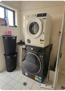 a washer and dryer in a small room at Book this Cozy Haven Room for your next stay Shared Facilities in Guildford