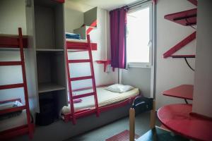 a room with four bunk beds and a window at Auberge de Jeunesse HI Paris Le d'Artagnan in Paris