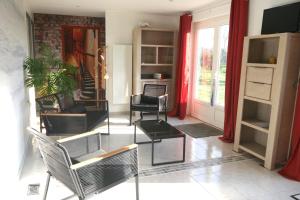 ein Wohnzimmer mit Stühlen und einem Tisch in der Unterkunft La maison dans le pré in Agon Coutainville