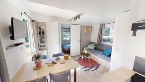 ein kleines Wohnzimmer mit einem Tisch und einem Sofa in der Unterkunft Camping Les Vernieres La Bourboule Sancy in La Bourboule