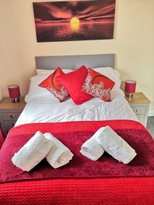 a bed with red and white towels on it at Nick's Place in Plymouth