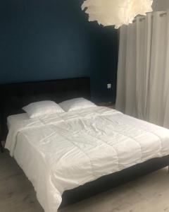 - un lit avec des draps et des oreillers blancs dans une chambre dans l'établissement Appartement T2 Bayonne avec parking, à Bayonne